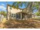 Home exterior with a screened-in porch and backyard with mature trees at 6799 Helmsley Cir, Windermere, FL 34786