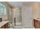Bathroom featuring a glass-enclosed shower, a window and vanity with a single sink at 6799 Helmsley Cir, Windermere, FL 34786