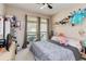 Cozy bedroom with a large window, ceiling fan, and playful decor at 6799 Helmsley Cir, Windermere, FL 34786