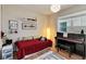 Bright guest bedroom featuring a red bed and a black piano at 6799 Helmsley Cir, Windermere, FL 34786