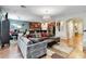 Spacious open-concept living area with hardwood floors, modern furniture, and a view of the kitchen at 6799 Helmsley Cir, Windermere, FL 34786