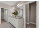 Bathroom with double sink vanity with granite countertop, large mirror, and walk-in closets at 7131 Desert Mandarin St, Winter Garden, FL 34787