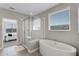 Modern bathroom with a soaking tub, glass shower, tile flooring, and a neutral color palette at 7131 Desert Mandarin St, Winter Garden, FL 34787