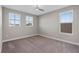 Neutral bedroom featuring a ceiling fan, carpeting and two large windows for ample natural light at 7131 Desert Mandarin St, Winter Garden, FL 34787