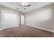 A neutral bedroom with a ceiling fan, carpeted floor, and large closet at 7131 Desert Mandarin St, Winter Garden, FL 34787
