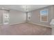 A spacious bonus room with two windows, neutral walls, and carpeted floors at 7131 Desert Mandarin St, Winter Garden, FL 34787