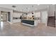 Spacious kitchen boasts tile floors, stainless appliances, granite counters, and a dark blue island with pendant lighting at 7131 Desert Mandarin St, Winter Garden, FL 34787