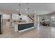 Open kitchen features granite counters, stainless appliances, tile floors, and pendant lighting over the dark blue island at 7131 Desert Mandarin St, Winter Garden, FL 34787