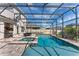 Large screened-in pool and spa surrounded by brick pavers and an outdoor kitchen for entertainment at 7131 Desert Mandarin St, Winter Garden, FL 34787