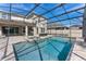 Full view of the screened-in pool and spa with an outdoor kitchen and covered patio at 7131 Desert Mandarin St, Winter Garden, FL 34787