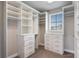Spacious walk-in closet with custom shelves and drawers, and window for natural light at 7131 Desert Mandarin St, Winter Garden, FL 34787