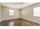 Spacious main bedroom featuring wood floors and natural light from two windows at 7355 Rush Ct, Orlando, FL 32818