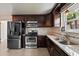 Bright kitchen features stainless steel appliances, stone countertops, and dark wood cabinets at 833 N Thornton Ave, Orlando, FL 32803