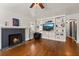 Cozy living room featuring a fireplace, hardwood floors, and a built-in entertainment center at 833 N Thornton Ave, Orlando, FL 32803