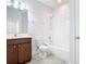 Well-lit bathroom with white tiling, a bathtub, and a wood-finished vanity at 869 Taramundi Dr, Oviedo, FL 32765