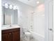 Well-lit bathroom with white tiling, a bathtub, and a wood-finished vanity at 869 Taramundi Dr, Oviedo, FL 32765