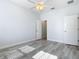 Bright bedroom has grey wood floors, ceiling fan, and access to the walk-in closet at 869 Taramundi Dr, Oviedo, FL 32765