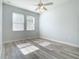 Sun-filled bedroom features gray wood floors, a ceiling fan, and bright natural light at 869 Taramundi Dr, Oviedo, FL 32765