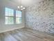 Dining room features modern chandelier, two windows, and a stone accent wall at 869 Taramundi Dr, Oviedo, FL 32765