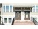 Inviting townhome entrances with neutral exteriors are accessed by brick stairs and black railings at 869 Taramundi Dr, Oviedo, FL 32765