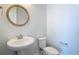 Powder room with traditional pedestal sink, modern faucet, and circular mirror at 869 Taramundi Dr, Oviedo, FL 32765