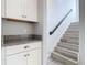 Staircase landing with white cabinets, stone countertop and wood-look stairs at 869 Taramundi Dr, Oviedo, FL 32765