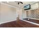 Bedroom with wood floors, ceiling fan and a wall of mirrors with a mounted television at 8872 Bismarck Palm Dr, Winter Garden, FL 34787