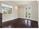 Bedroom featuring dark hardwood floors, a large window for natural light, and access to an outdoor balcony through French doors at 8872 Bismarck Palm Dr, Winter Garden, FL 34787