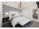 Comfortable bedroom with patterned accent wall, plush carpet, and stylish lighting at 8872 Bismarck Palm Dr, Winter Garden, FL 34787