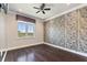 Bedroom with striking wallpaper, hardwood floors, a large window with blinds, and modern ceiling fan at 8872 Bismarck Palm Dr, Winter Garden, FL 34787