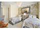 Comfortable bedroom with two twin beds, floral wallpaper, and modern lighting at 8872 Bismarck Palm Dr, Winter Garden, FL 34787