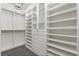 Bright, open walk-in closet with custom shelving, drawers and patterned carpet at 8872 Bismarck Palm Dr, Winter Garden, FL 34787