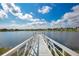 Picturesque view of a lake with a long dock, clear blue skies, and neighboring houses in the distance at 8872 Bismarck Palm Dr, Winter Garden, FL 34787
