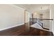 Upstairs hallway boasts dark hardwood floors and a staircase with modern, decorative iron railings at 8872 Bismarck Palm Dr, Winter Garden, FL 34787