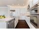 Modern white kitchen features stainless steel appliances, a farmhouse sink, and a marble countertop island at 8872 Bismarck Palm Dr, Winter Garden, FL 34787