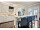 Modern kitchen with a stone-clad island, white cabinetry, stainless steel appliances, and stylish bar seating at 8872 Bismarck Palm Dr, Winter Garden, FL 34787