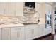 Modern kitchen with white cabinets, granite countertops, tile backsplash, and stainless steel appliances at 8872 Bismarck Palm Dr, Winter Garden, FL 34787
