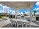 Community outdoor grilling area features a dining table, grill and view of the playground and lake at 8872 Bismarck Palm Dr, Winter Garden, FL 34787
