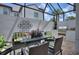 Relaxing screened patio with outdoor seating, a grill, and views of lush landscaping at 8872 Bismarck Palm Dr, Winter Garden, FL 34787