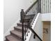 A staircase with carpeted steps, detailed wood banister, and decorative metal railing at 14645 Scott Key Dr, Winter Garden, FL 34787