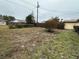 Wide backyard with a wood fence, sparse grass, and views of neighboring homes at 1486 Randolph St, Deltona, FL 32725