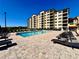 Relaxing pool area with lounge chairs and an apartment building in the background at 16300 County Road 455 # 513, Montverde, FL 34756