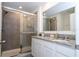 Well-lit bathroom with granite counters, double sinks, and glass-enclosed shower with tile surround at 17101 Water Spring Blvd, Winter Garden, FL 34787