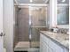 Bathroom featuring glass-enclosed shower with tile surround, and vanity with granite counters at 17101 Water Spring Blvd, Winter Garden, FL 34787