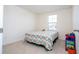 Cozy bedroom with carpet, a window, and a colorful patterned bedspread at 17101 Water Spring Blvd, Winter Garden, FL 34787