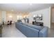 Bright open-plan living room and kitchen with modern gray sofa and eat-in kitchen area at 17101 Water Spring Blvd, Winter Garden, FL 34787