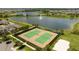 Aerial view of tennis courts close to beautiful lake and well-manicured landscaping at 17101 Water Spring Blvd, Winter Garden, FL 34787