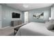 Serene bedroom featuring a chic wall design, a modern TV, and an adjacent bathroom at 1720 Sawyer Palm Pl, Kissimmee, FL 34747