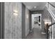 Elegant hallway with modern textured wallpaper, decorative sconces, and staircase leading to the upper level at 1720 Sawyer Palm Pl, Kissimmee, FL 34747