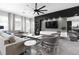 Bright living room featuring a modern entertainment center, sleek furniture and gray ceramic flooring at 1720 Sawyer Palm Pl, Kissimmee, FL 34747